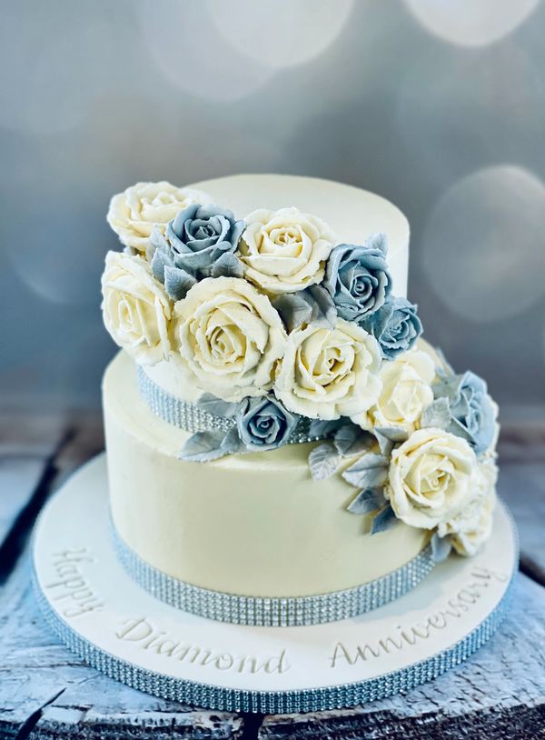 Ivory buttercream cake with handpiped buttercream roses in ivory and silver for a diamond wedding an