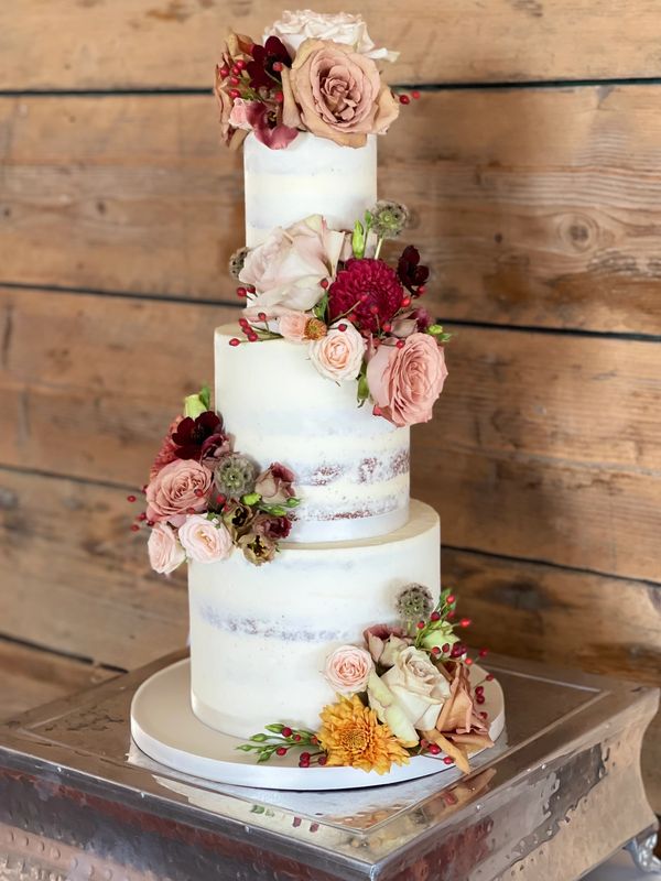 Autumn colours fresh flowers on 3 tier semi naked wedding cake