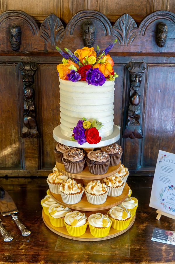 Rustic Wedding cake with cupcakes on wooden stand