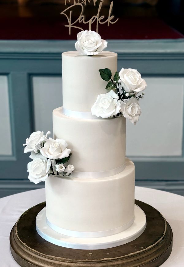 Elegant white fondant 3 tier wedding cake with handmade white sugar roses
