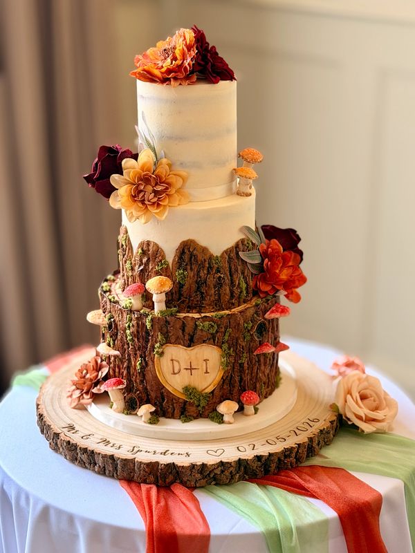 Woodland tree stump and semi naked wedding cake  with toadstools and silk flowers