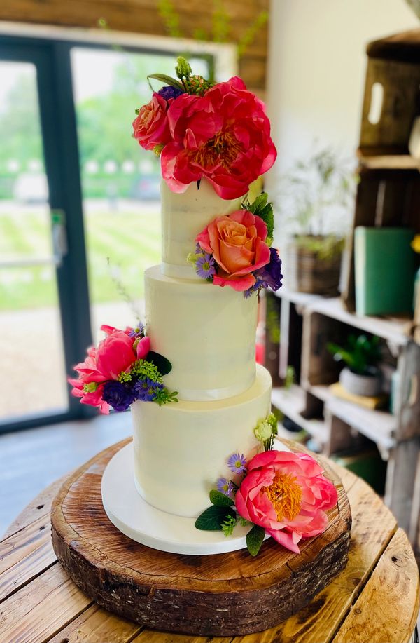 3 Tier Ivory Semi Naked wedding cake with stunning fresh flowers