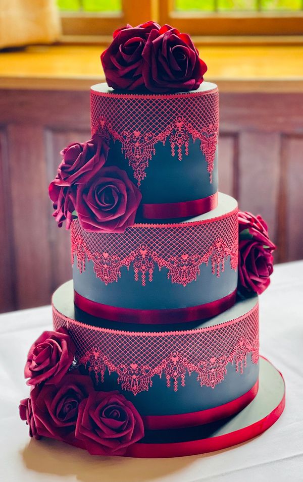 Elegant Gothic wedding cake, 3 tiers of black fondant cake with red cake lace and silk roses
