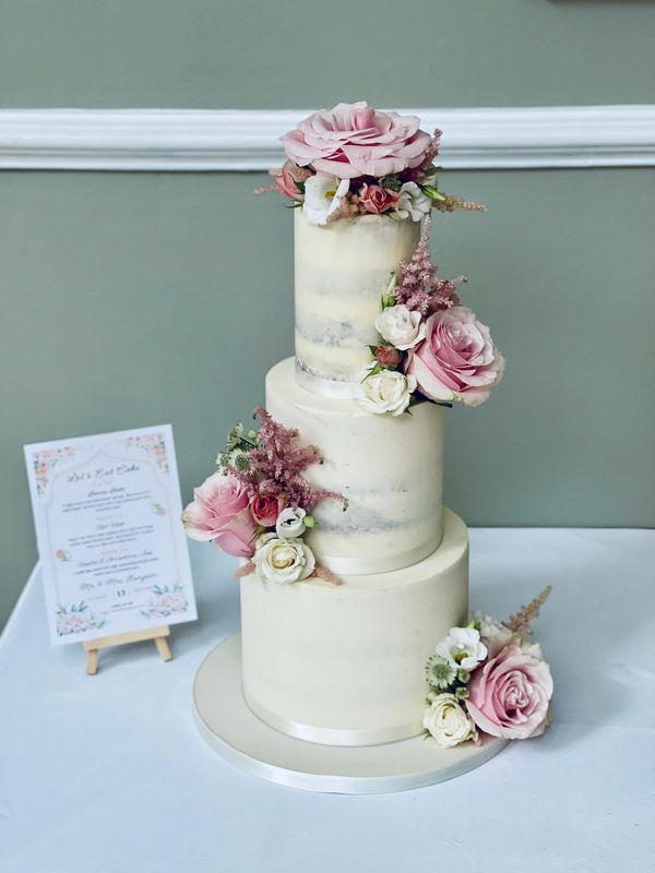 3 tier semi naked wedding cake with ivory buttercream and pretty fresh pink and white flowers