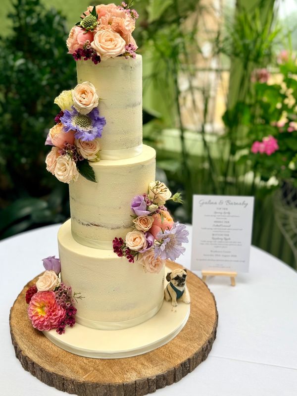 3 tier semi naked rustic wedding cake with pretty fresh flowers