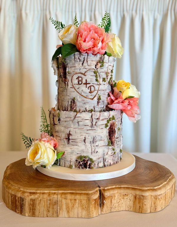 Silver Birch tree stump wedding cake with carved initials in heart and silk flowers