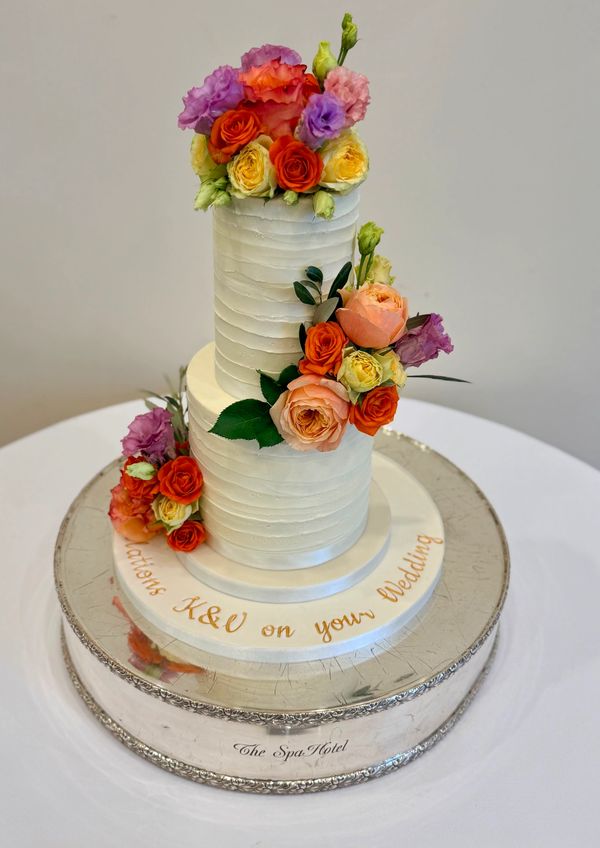 Rustic textured buttercream wedding cake with fresh flowers