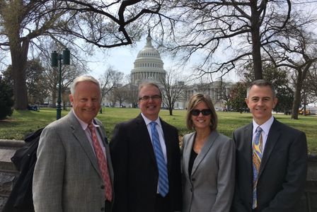 Bankers standing outside in Washington DC with the Capitol Building in the background.