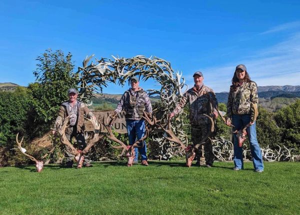 Four hunters with large elk antlers.