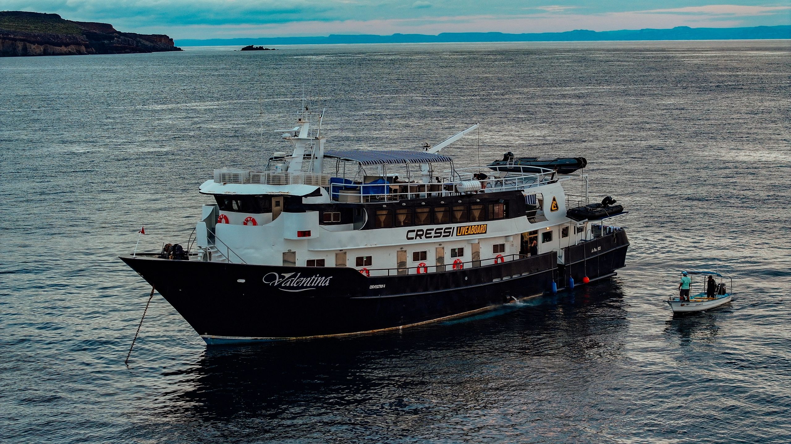 Large boat named Valentina on calm sea with a smaller boat nearby.