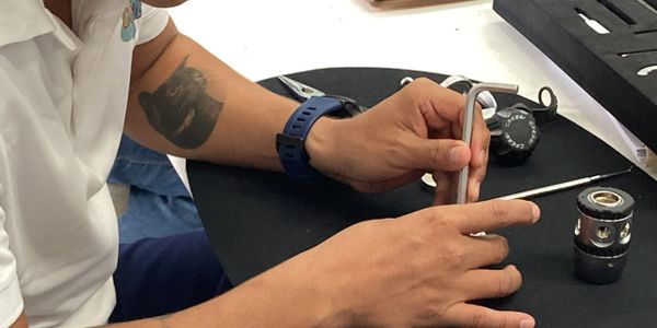 Person using an Allen wrench to work on a mechanical part.