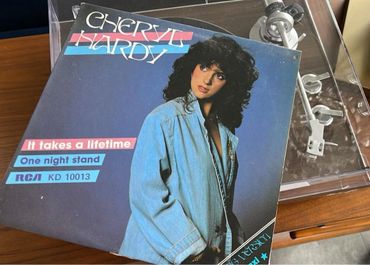 Cherrelle Hardy's record cover featuring a woman in a denim jacket beside a turntable.