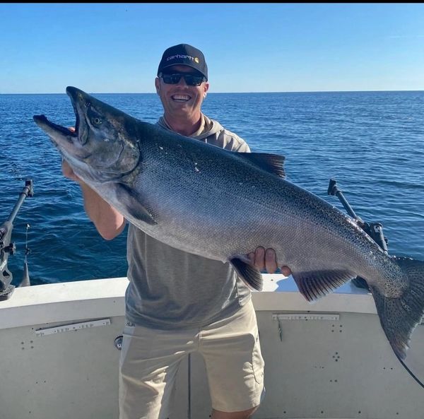 A happy customer holding a King Salmon on one of our Sturgeon Bay fishing charters. 