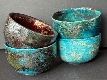 Stack of rustic ceramic bowls with turquoise glaze.