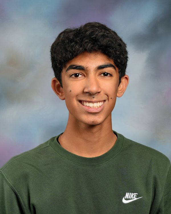 Young man smiling in a green Nike sweatshirt against a soft gradient background.