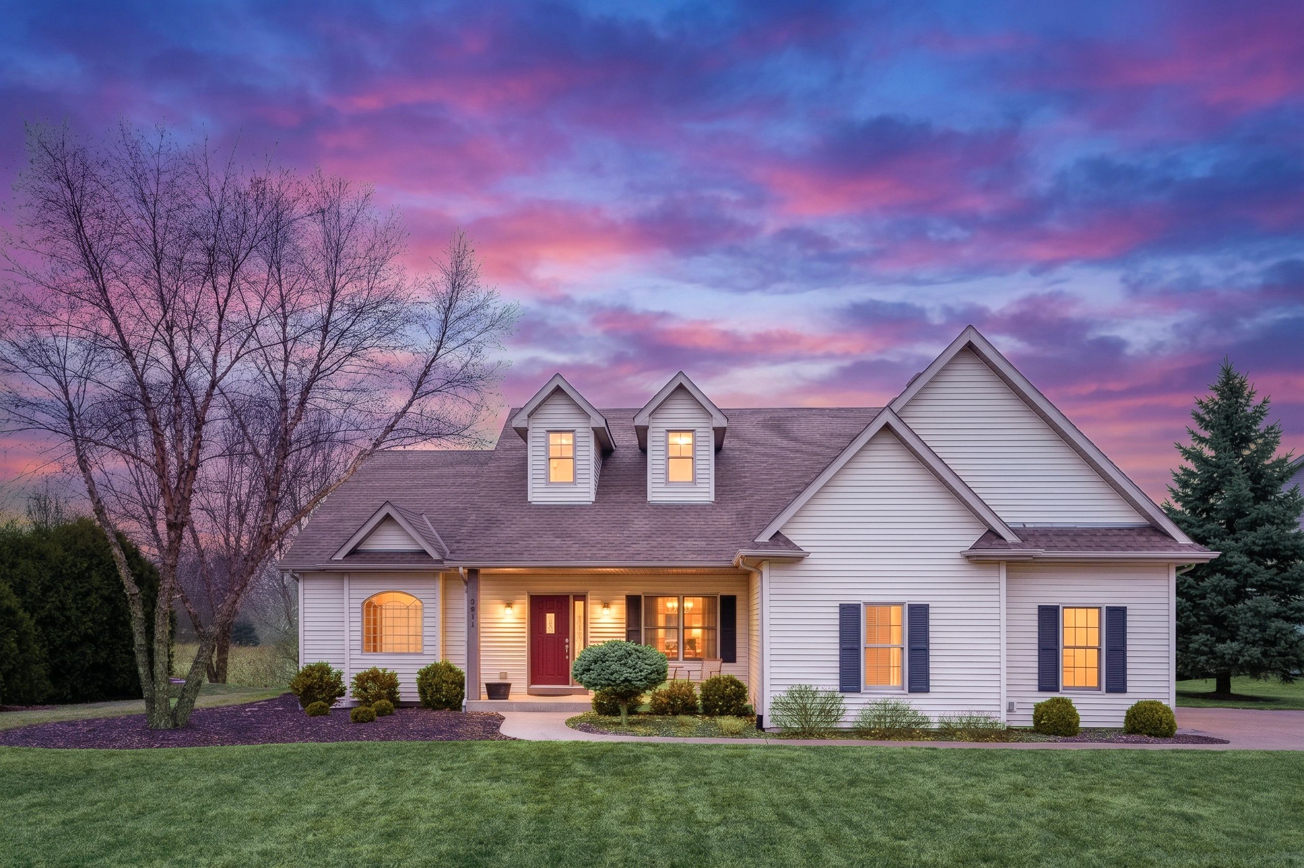 Cozy suburban house at sunset with colorful sky.