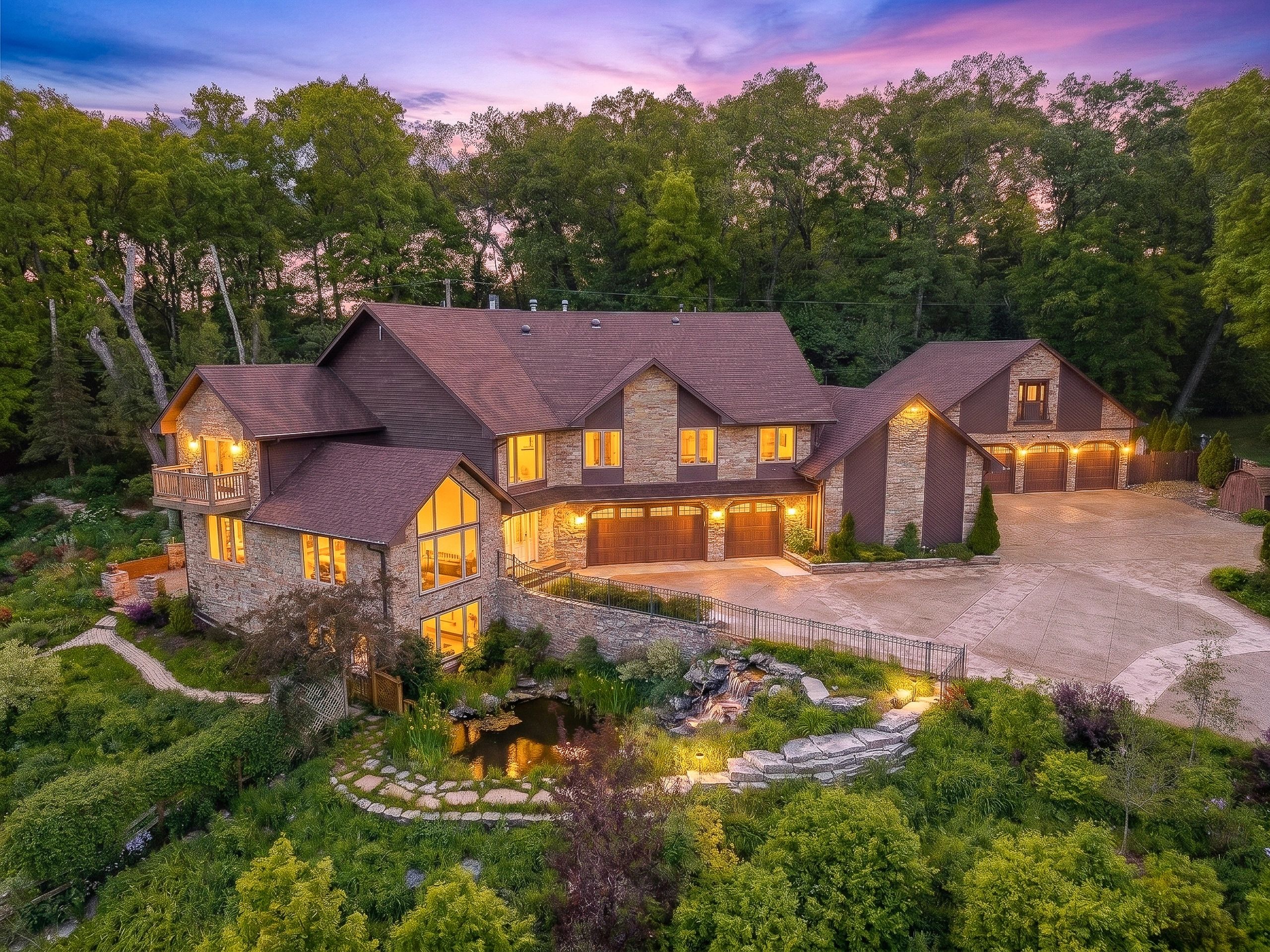 Luxury Kenosha WI home at twilight, glowing windows, cinematic blue hour real estate photo.