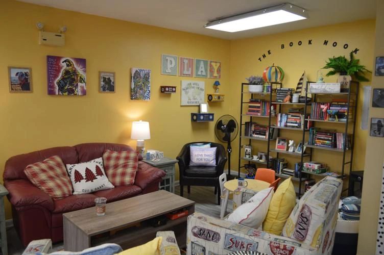 Cozy reading nook with comfy sofas, colorful decor, and a well-stocked bookshelf.