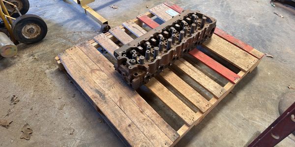 Engine cylinder head on a wooden pallet.