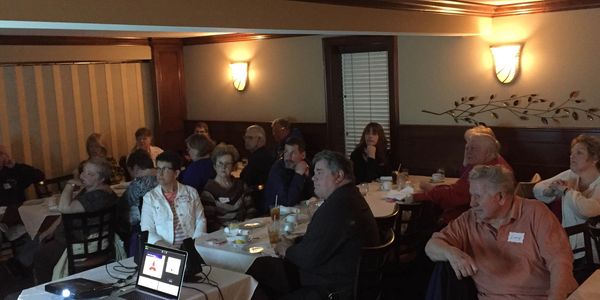 This image shows attendees at a Free Dinner Seminar during the presentation on MLS Laser Therapy.