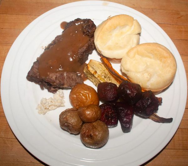 Plate with steak, biscuits, roasted potatoes, and vegetables.
