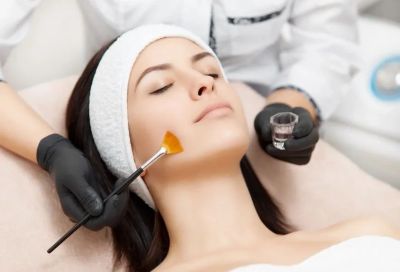 A woman receiving a facial treatment with a brush application.