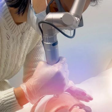Professional performing a laser skin treatment on a patient's face.