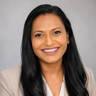 Professional woman with long black hair smiling at the camera.