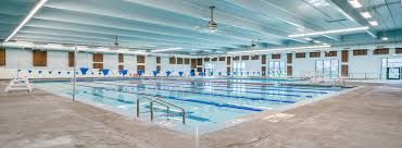 A large indoor swimming pool with multiple lanes and bright lighting.