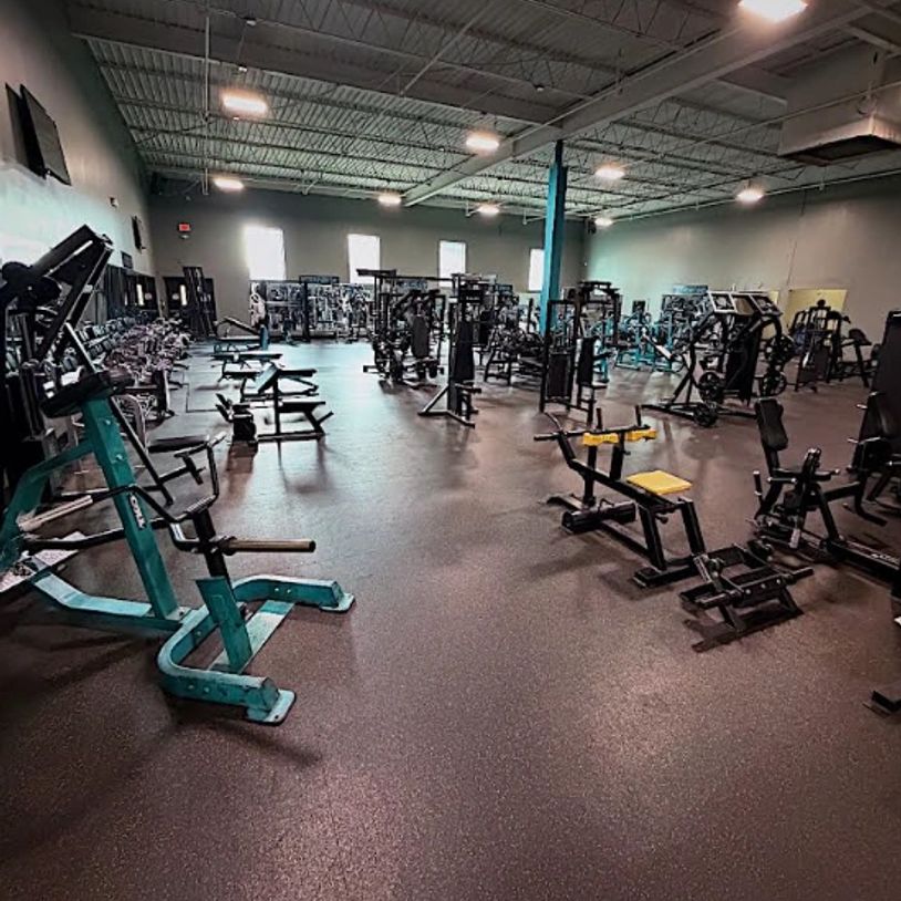 Spacious gym with various exercise machines and equipment.