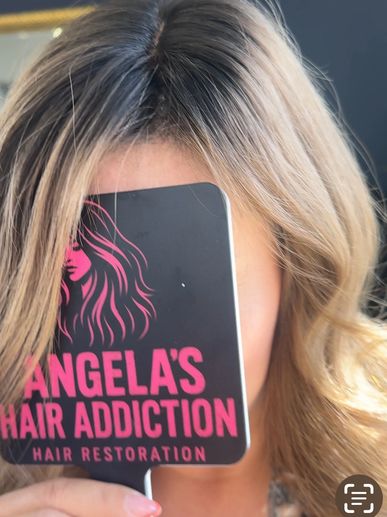 Woman holding a branded hairbrush covering her face, showcasing styled hair.