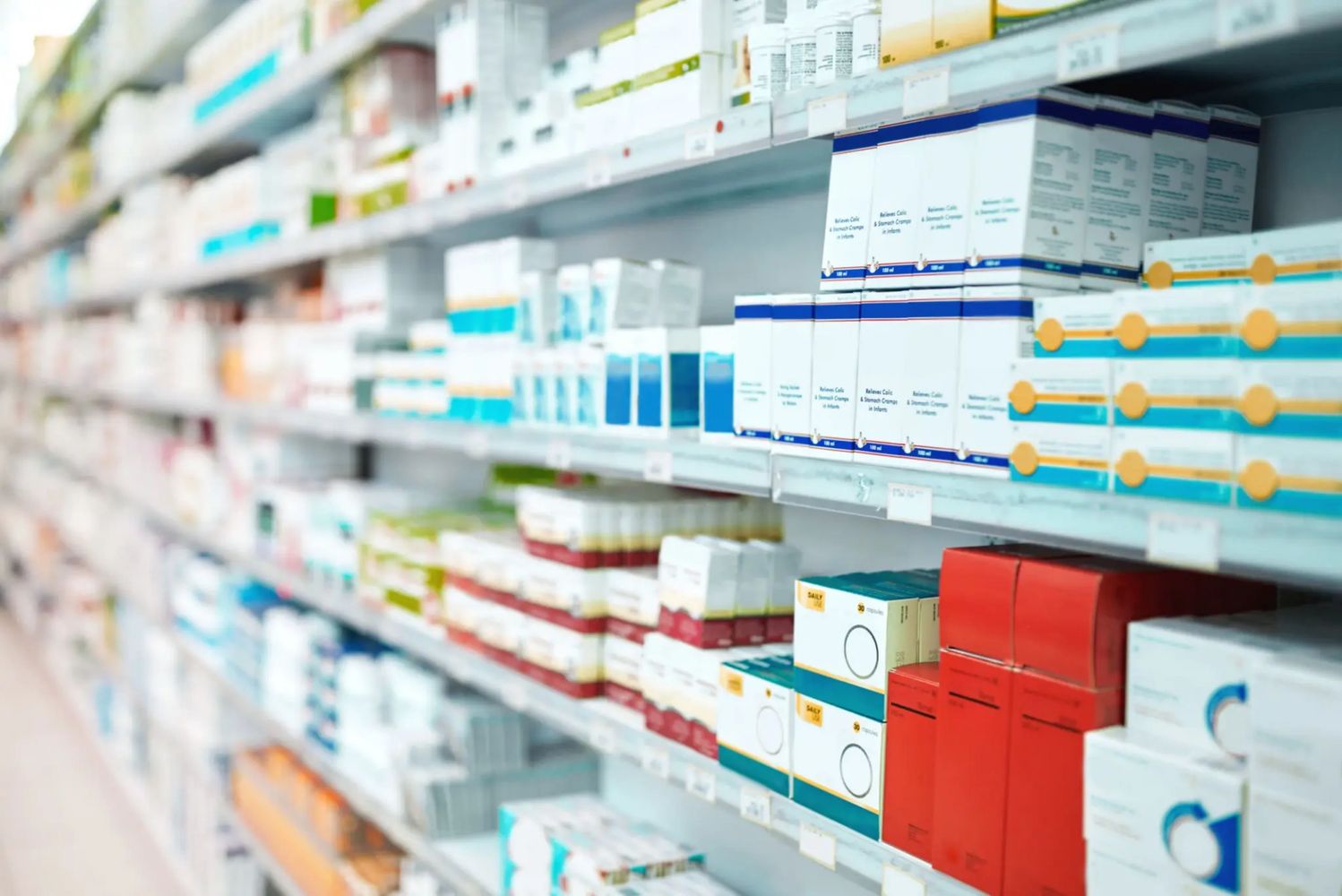Pharmacy shelves stocked with various medicines and health products.