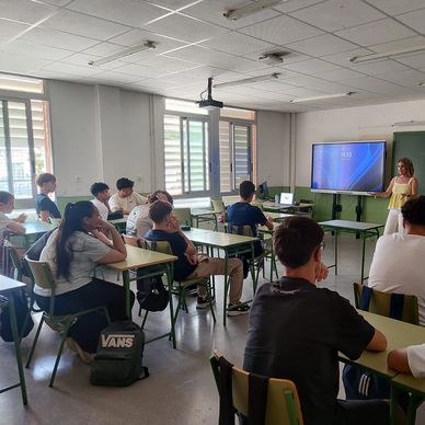 Estudiantes atentos en una clase con presentación.