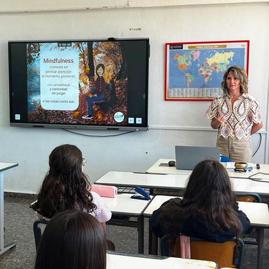 Clase sobre mindfulness con una profesora y estudiantes en aula.