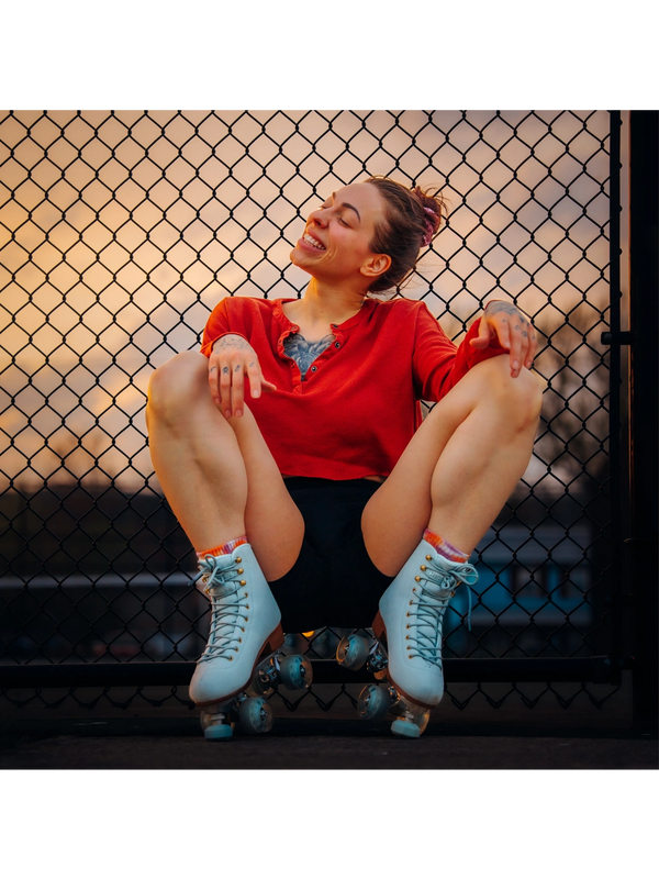 Harlow Harrison Bio. Harlow Harrison about me. Harlow Harrison on skates by a fence, smiling. 