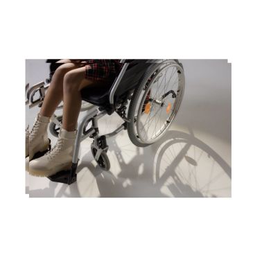 Person in wheelchair wearing white boots.