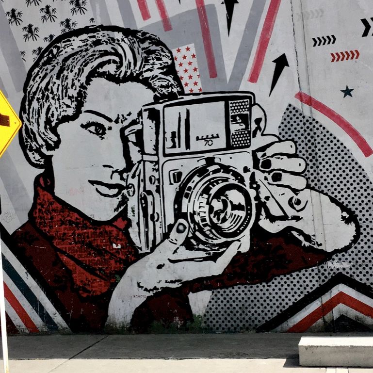 Black, white & red mural of a woman taking a picture