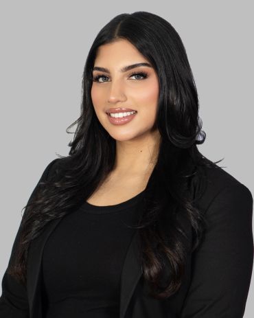 Smiling woman with long black hair in black outfit.