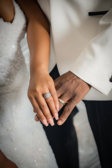 Couple holding hands showing wedding rings.
