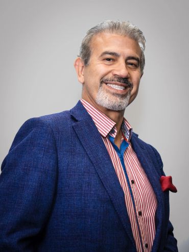 Confident man in blue blazer smiling.