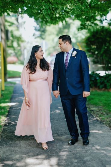 Couple holding hands and walking outdoors.