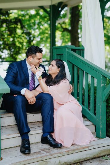 Couple sitting on steps, gazing affectionately.