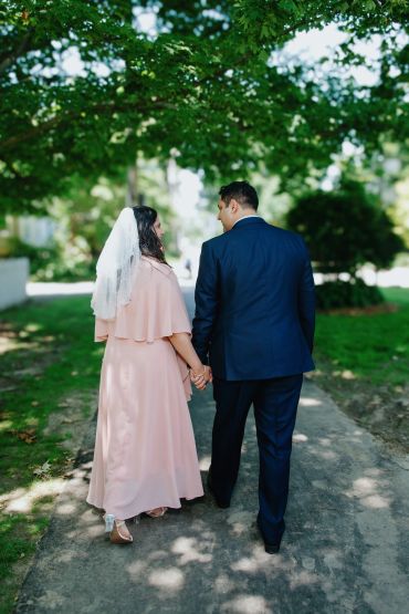 Couple holding hands walking outdoors.