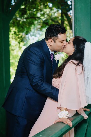 Couple sharing a kiss outdoors during wedding.