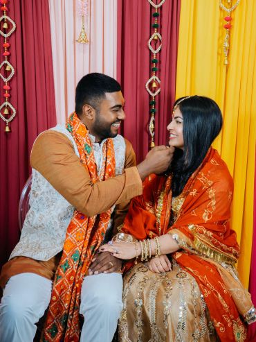 Couple in traditional attire sharing a joyful moment.