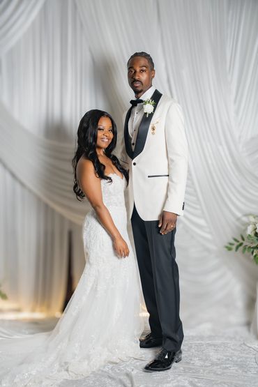 Elegant couple posing in wedding attire.