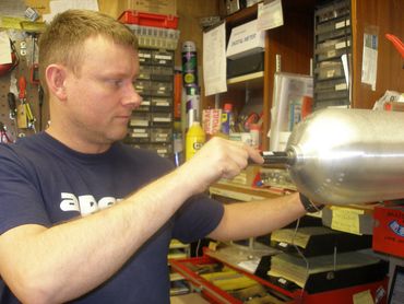 Technician using a plug gauge to check threads of a cylinder