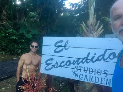 2 tourists in front of the resort sign.