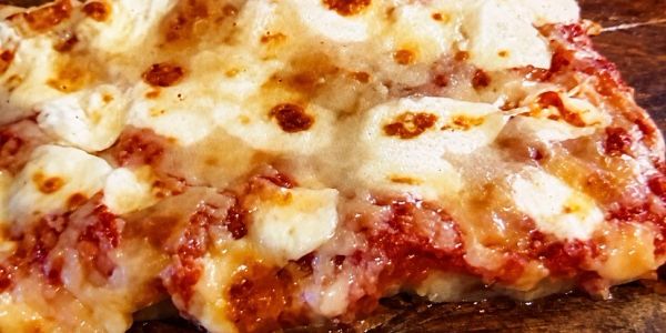 Close-up of cheesy pizza slice.