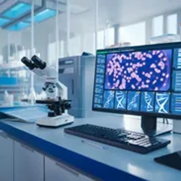 Modern laboratory with microscope and computer analyzing cell images.